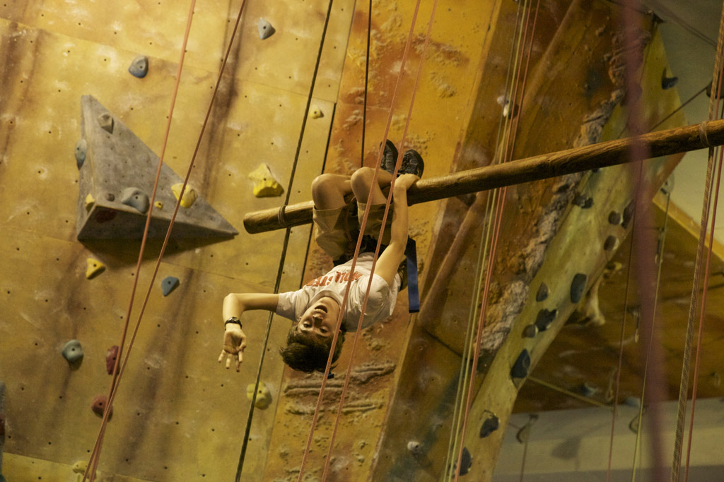David hangs upside down at the rock gym